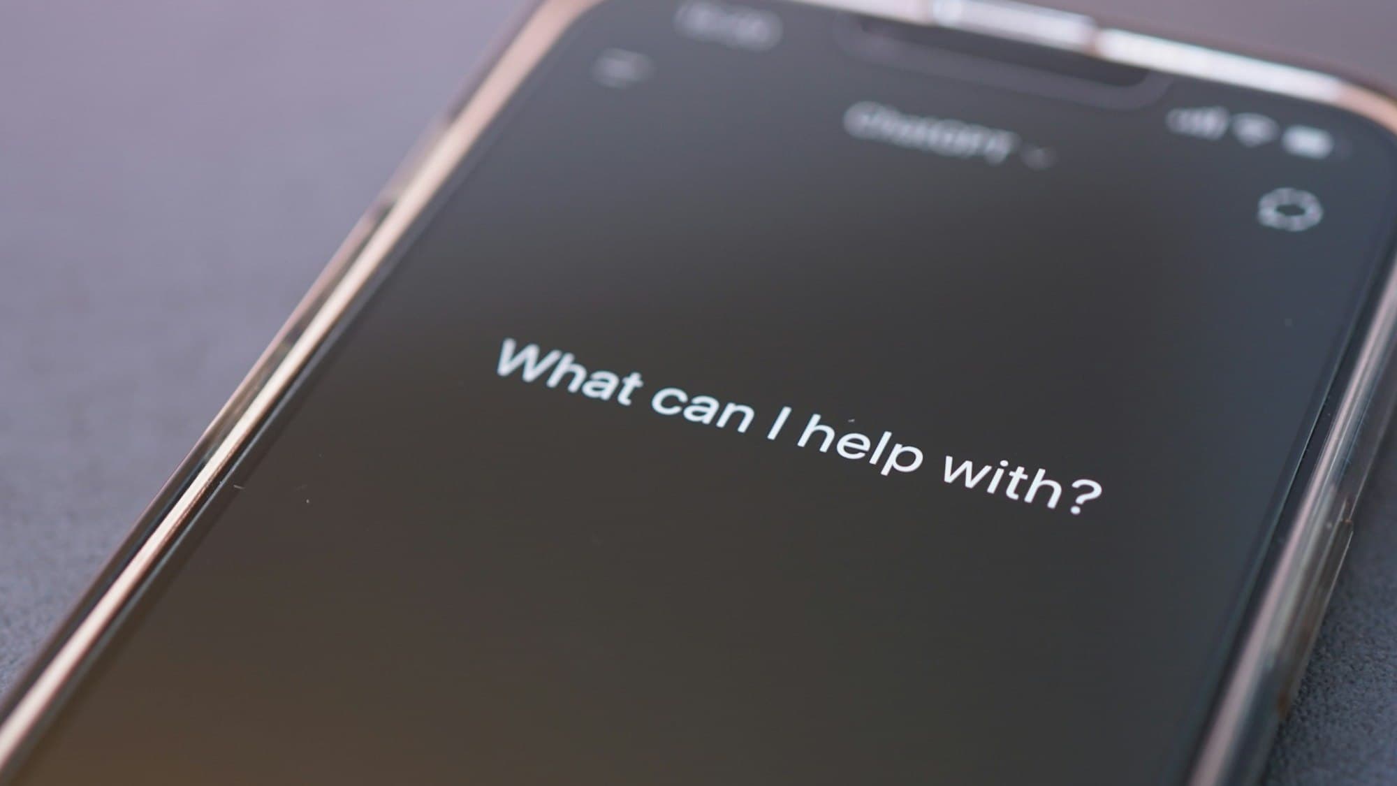 Telefoon met een geopende AI-assistent die vraagt: What can I help with?