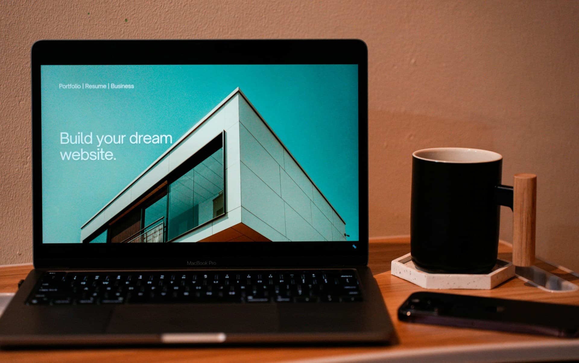 Laptop met een websitebouwer die de tekst Build your dream website toont